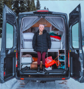 a woman in a camper van with a suitcase