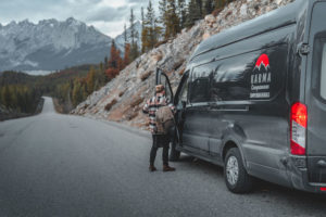 Karma Campervan in Canadian Rocky Mountains with male putting on backpack