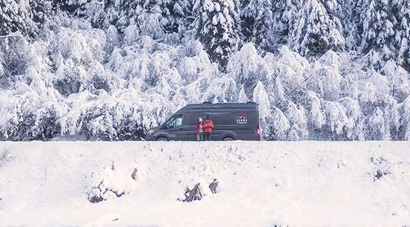 a camper van on a snowy mountain with snow on the ground